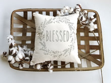Blessed pillow in a woven basket surrounded by cotton 