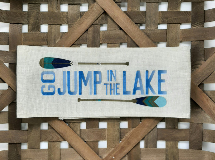 Go jump in the lake faux burlap off - white pillow wrap sitting in a woven basket
