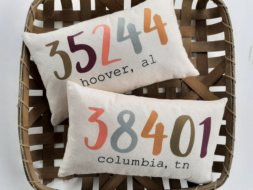 two customized colorful zip code pillows sitting inside a woven basket