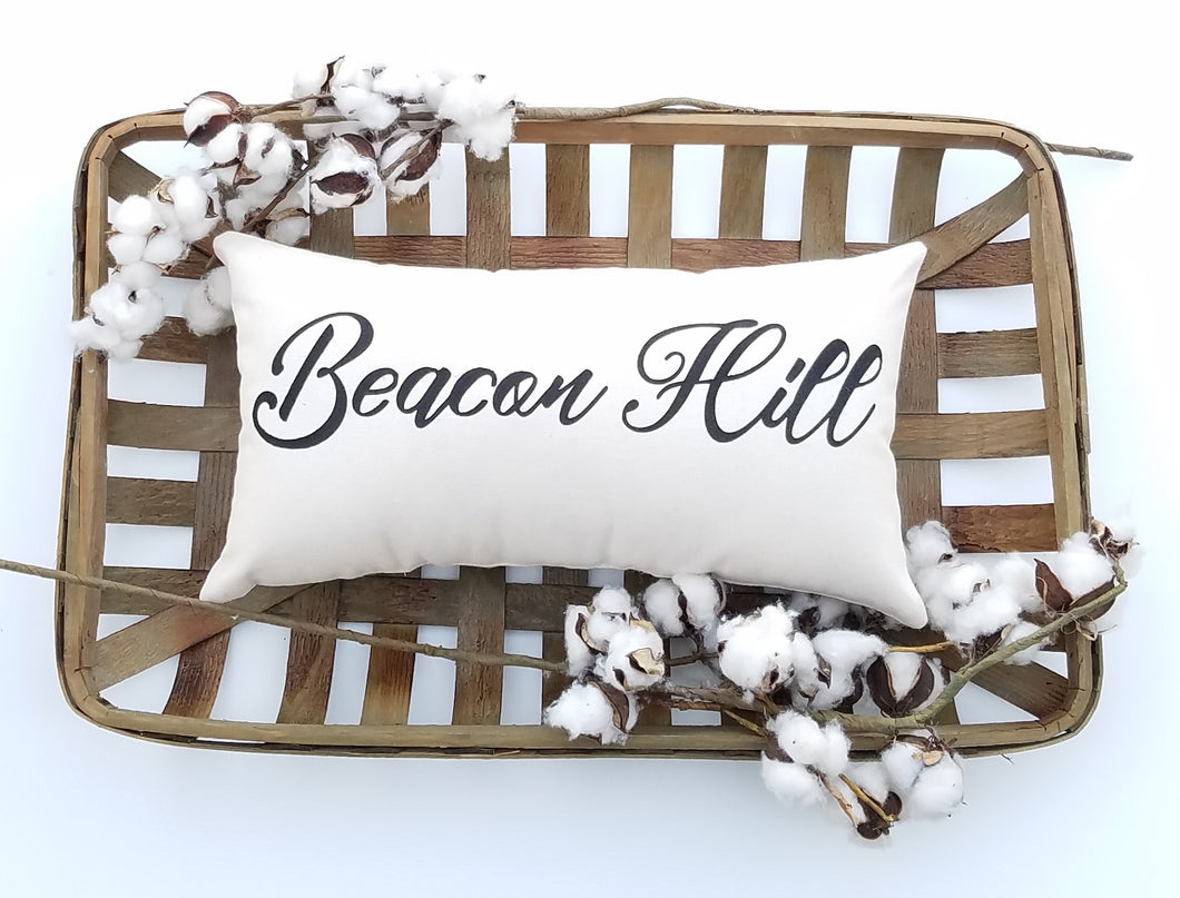 custom hometown city lumbar pillow in a woven basket decorated with cotton
