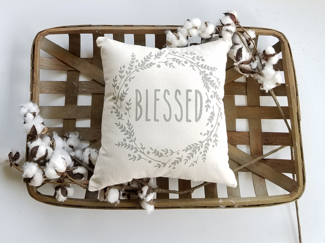 Blessed pillow in a woven basket surrounded by cotton 