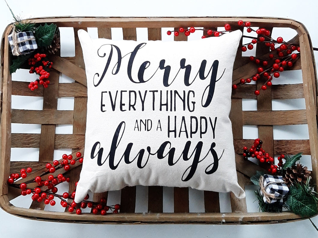 Merry Everything and a Happy Always Christmas Pillow, sitting inside a woven basket that is decorated with holiday berries