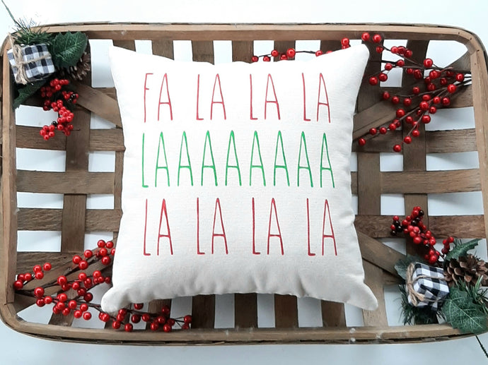 Fa La La  Christmas pillow in a woven basket decorated with red berries 
