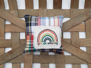 You Are Amazing Rainbow Patchwork Mini Pillow sitting inside a woven basket