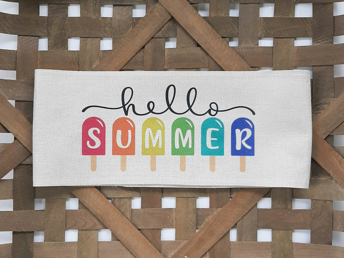 Hello Summer Faux Burlap Off-White Pillow Wrap against a woven basket background