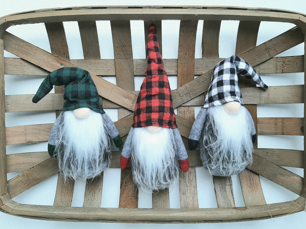 red/green/black and white plaid hat gnomes sitting inside a woven basket