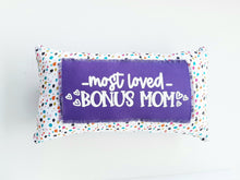 colorful polka dot pillow that reads most loved bonus mom laying against a white background 