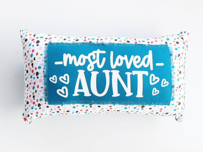 colorful polka dot pillow that reads most loved aunt against a white background