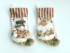 snowman and Santa plush stockings laying against a white background
