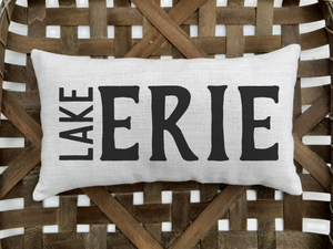 customizable lake pillow that reads lake erie, sitting inside a wooden basket
