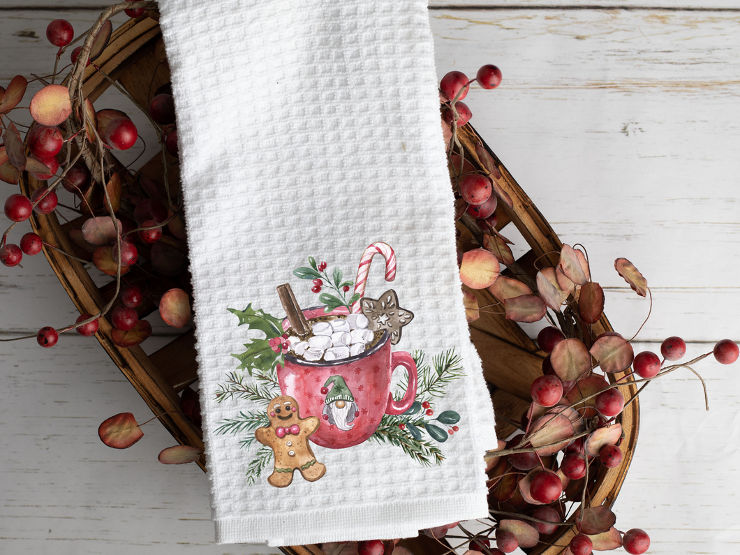 Hot Chocolate Bar Tea Towel with pictured Gingerbread and Gnome Hot Cocoa Mug on it, laying across a woven basket with berries