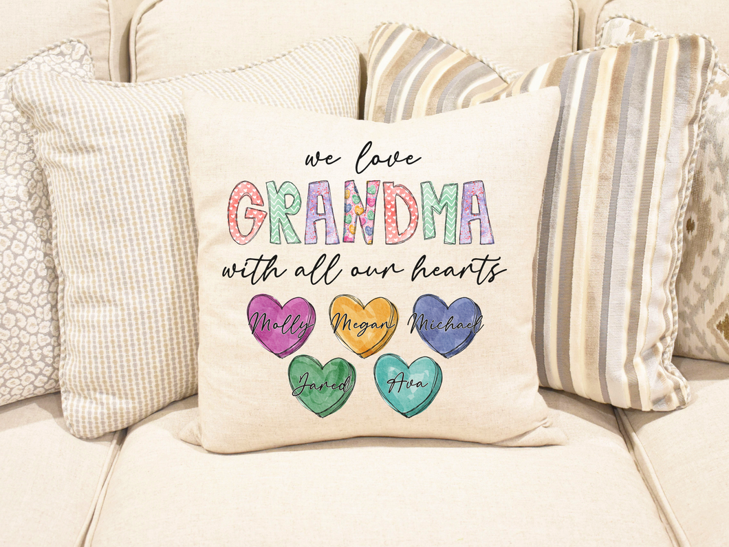 We love you with all our hearts, customized with names, colorful pillow, sitting on a couch with other pillows 