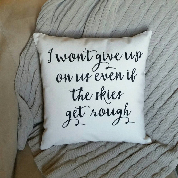I won't give up on us even if the skies get rough pillow sitting against a grey blanket