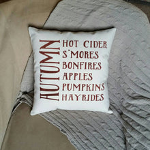 Smore's, Bonfires, Apples, Pumpkins, Hayrides Pillow | Autumn Decor pillow sitting on a couch with a grey blanket 