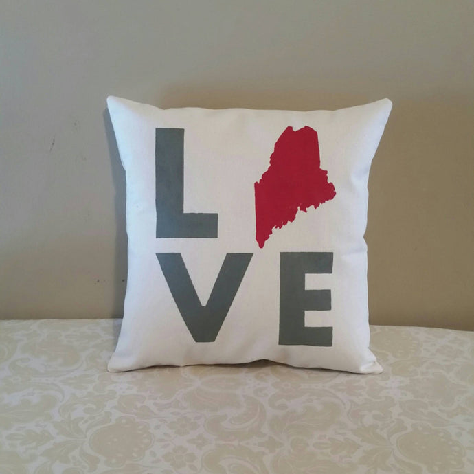 custom state LOVE pillow leaning against a tan wall