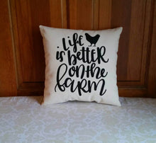 Life is Better on the Farm Farmhouse Style Pillow with Rooster, leaning against a wooden door