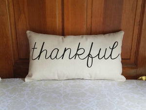 thankful modern farmhouse decorative pillow, leaning against a wooden door