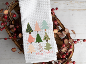 Retro Colorful Christmas Trees Merry Christmas Tea Towel, laying a across a basket filled with decorative berries 