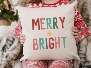 girl in Christmas pajamas holding aMerry and Bright Christmas Pillow