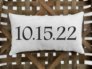 customizable special date pillow, sitting inside a woven basket 