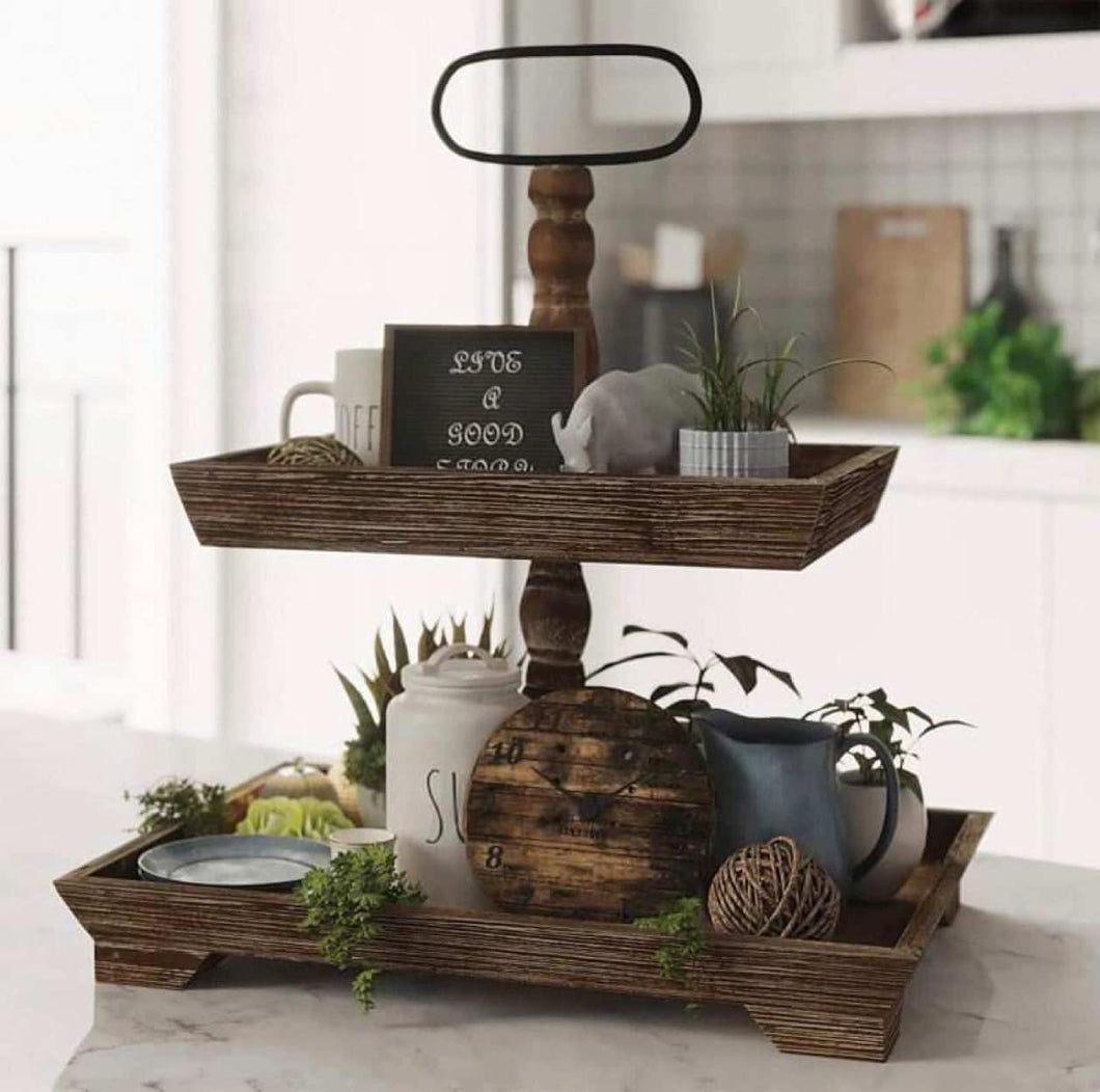 wooden farmhouse rectangle tiered stacked trays filled with decorative trinkets sitting on a marble white kitchen counter